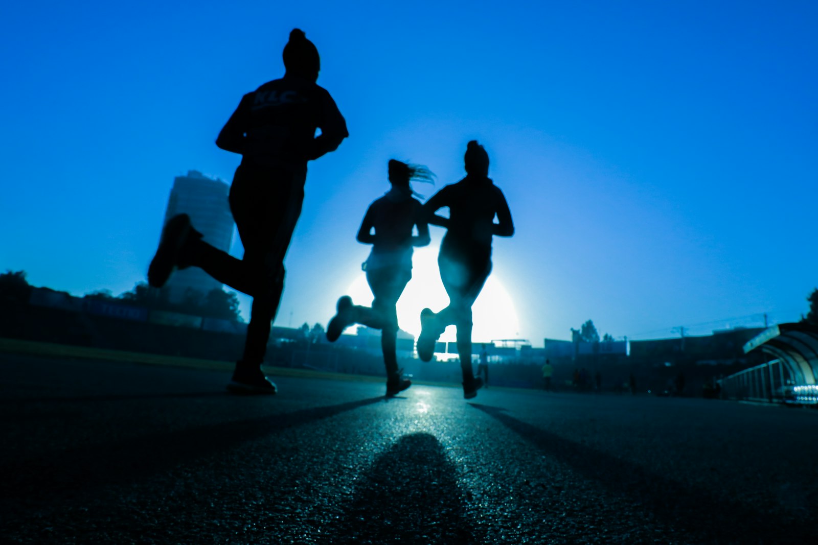 Three runners on a road at dawn